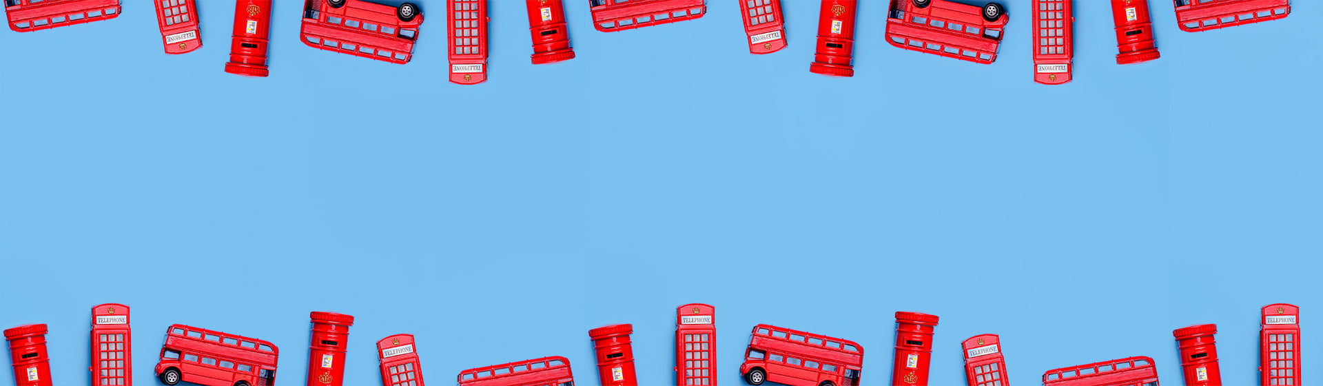 Red telephone boxes, buses and post boxes arranged in a pattern on a blue background
