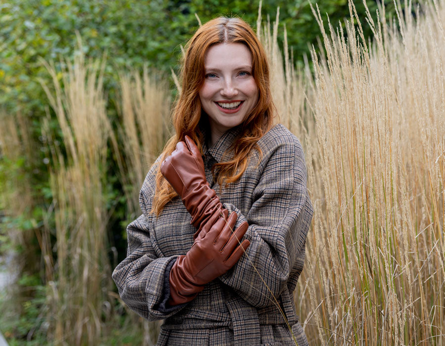 Woman wearing long leather gloves in brown with tweed coat 