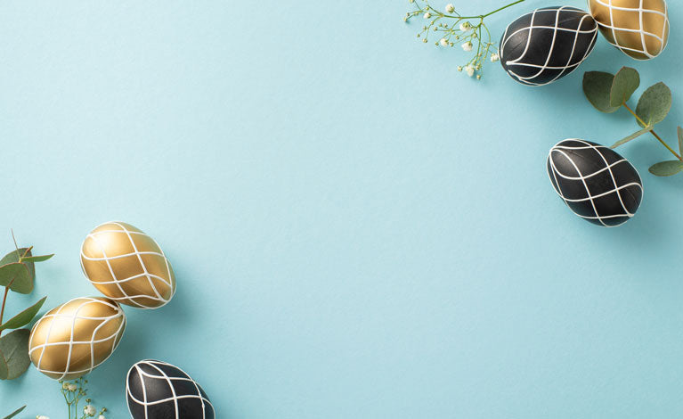 Blue background with gold and black easter eggs and babys breath flower.