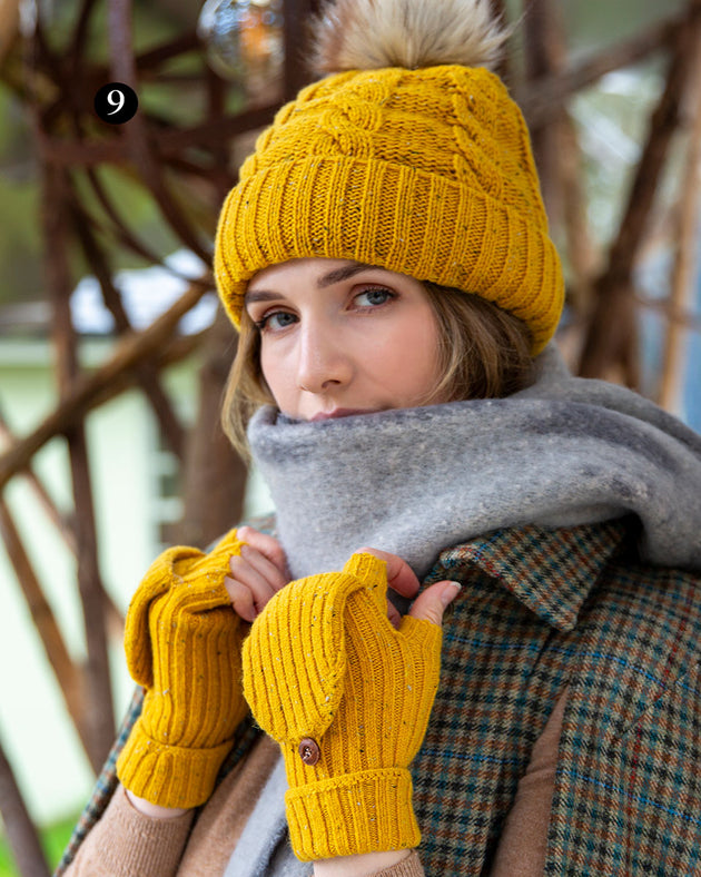 Woman wearing ribbed knit fingerless gloves with mitten flap in ochre