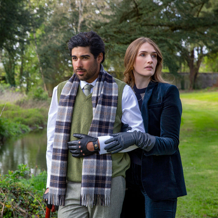 Man wearing Men's Heritage Tartan Check Cashmere Scarf with Tassels in Silver Bannockbane in the park
