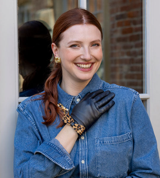 Woman wearing leather gloves with leopard print bow outdoors