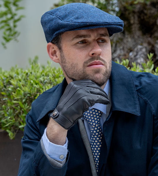 A man wearing a blue flat cap outdoors