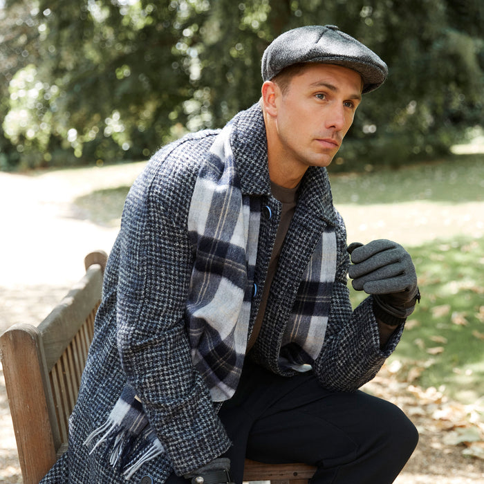 man wearing lambswool scarf in silver bannockbane sitting on a park bench