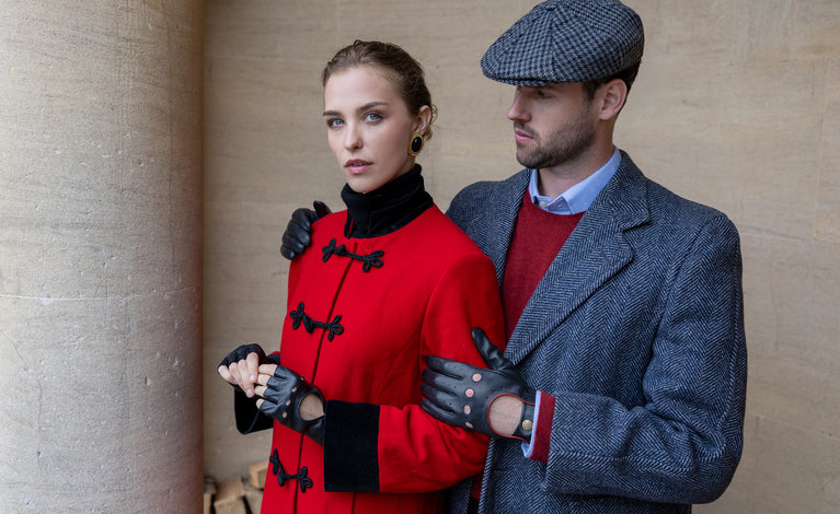A man and a woman wearing leather driving gloves in black outdoors