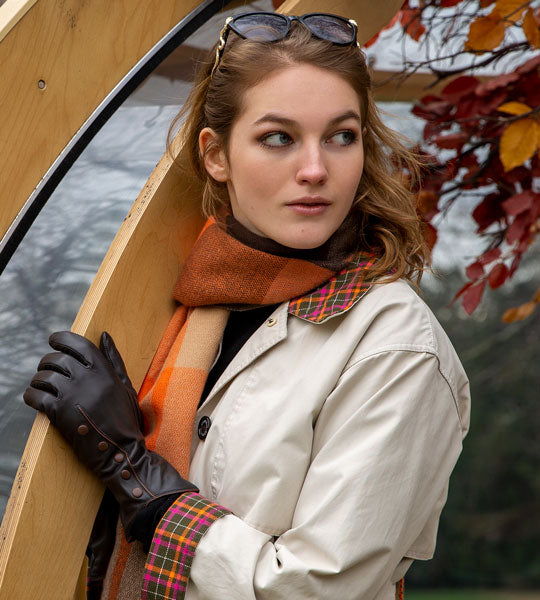 woman wearing leather gloves with buttons and pipping in mocca on an autumnal walk