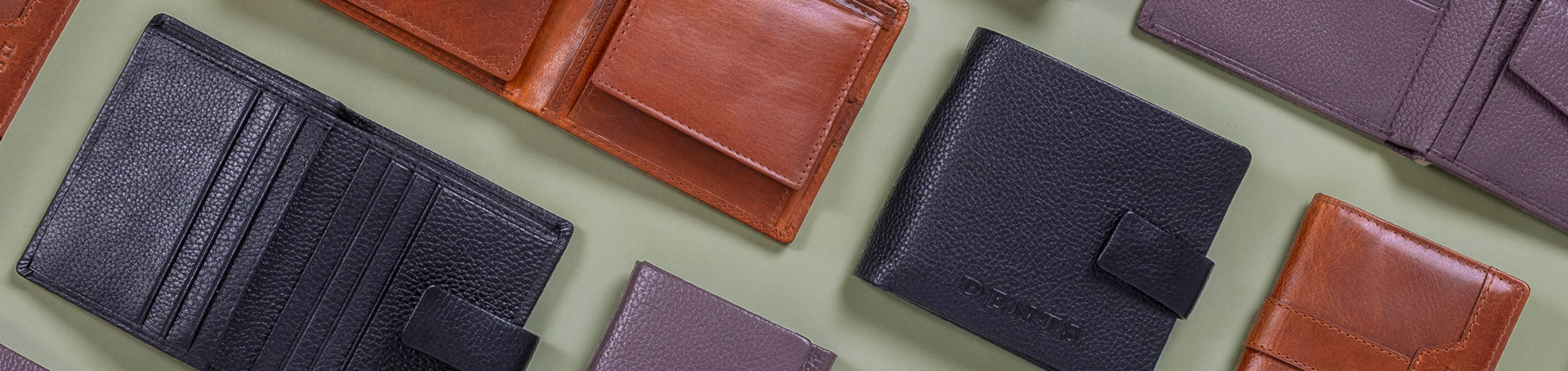 Men's leather wallets in various colours and styles on a green background