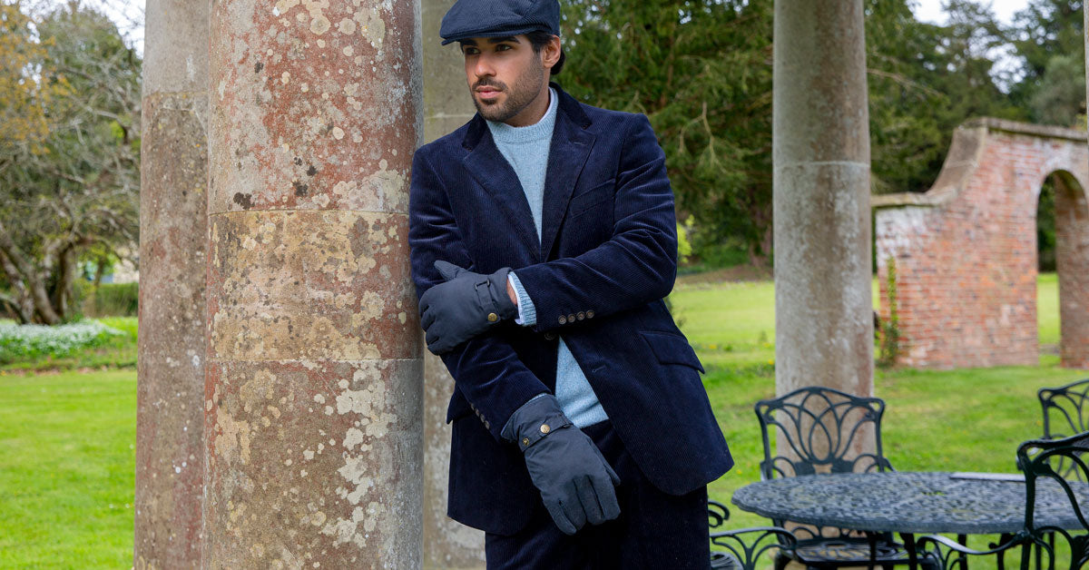 Man wearing water-resistant gloves in navy with a jacket walking around an estate
