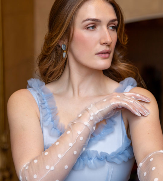 Woman wearing spotty tulle gloves in white with ballgown dress. 