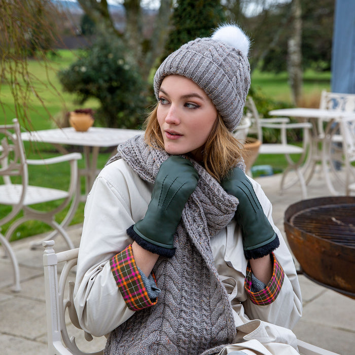 Woman wearing leather mittens in sage whilst sitting outside a cafe