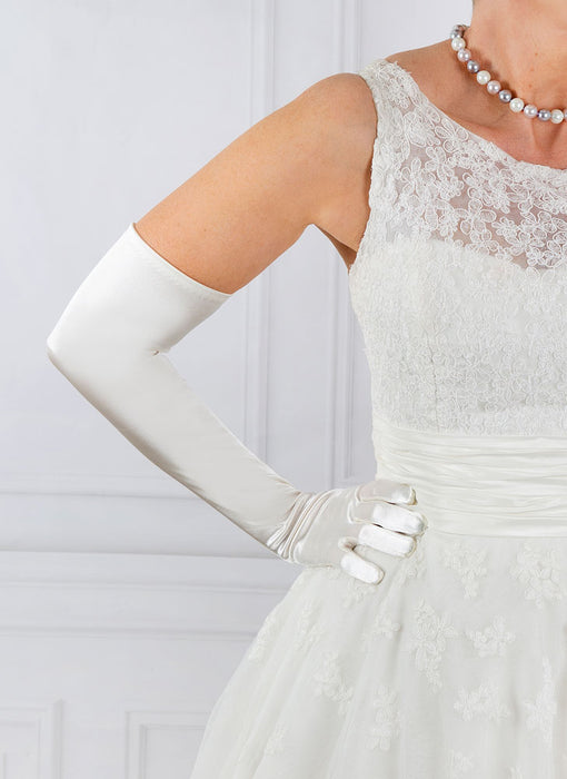 Woman wearing ivory opera satin gloves with a wedding dress